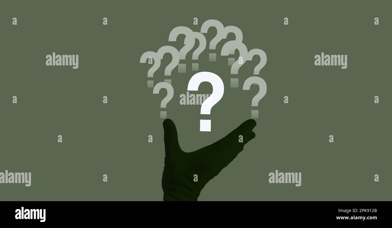 Eine menschliche Hand und weiße Fragezeichen auf grünem Hintergrund Stockfoto