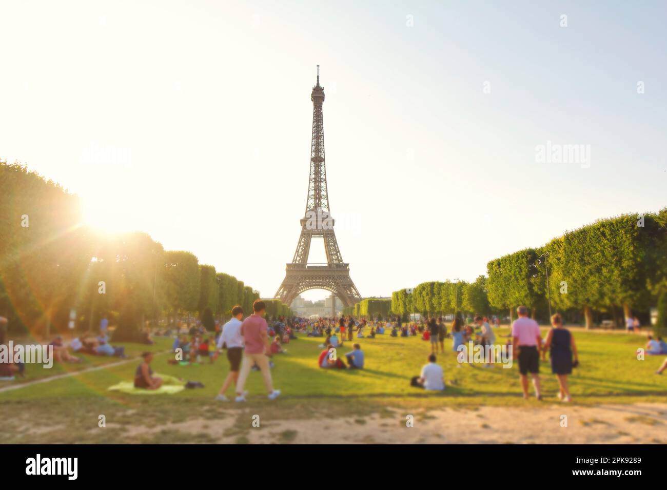 Der Eiffelturm in Paris, bedeckt mit hellem Sonnenlicht und verschwommenem Vordergrund Stockfoto