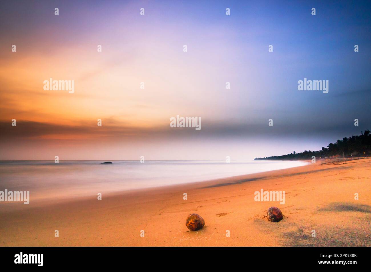 Sandstrand in Sri Lanka in der Nähe von Bentota, Sonnenuntergang am Abend, wunderschöner tropischer Strand mit Felsen Stockfoto