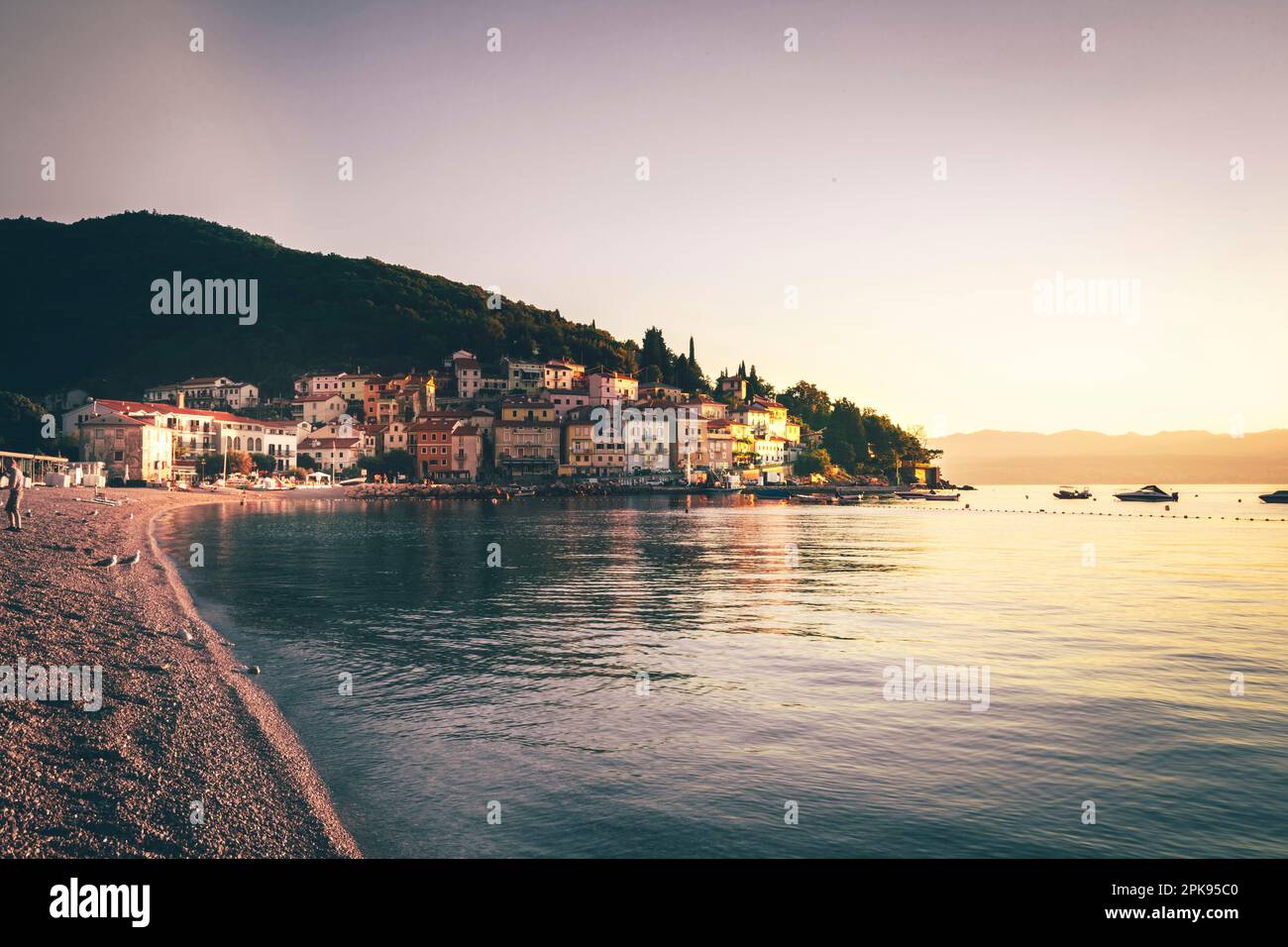 Wunderschöner Sonnenaufgang am Morgen. Sandstrand in der Bucht von Moö-eni-ka Draga mit Blick auf die Altstadt und den Hafen. Urlaubsregion Istrien, Kroatien Stockfoto
