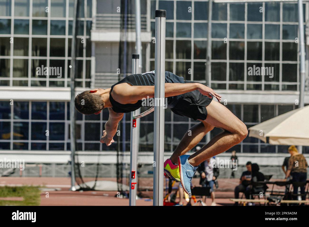 Männlicher Jumper, High-Sprung, Seitenansicht, erfolgreicher Versuch in Leichtathletik-Sprüngen, Sommer-Sportmeisterschaft Stockfoto