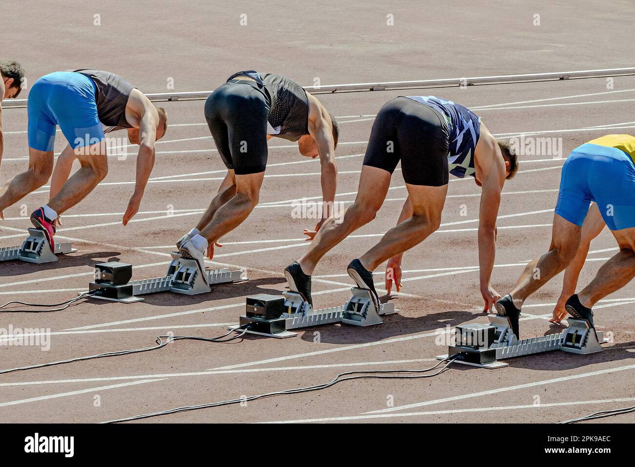 Gruppensprintläufer in Startposition bereit, 100-Meter-Rennen bei der Sommersportmeisterschaft Stockfoto