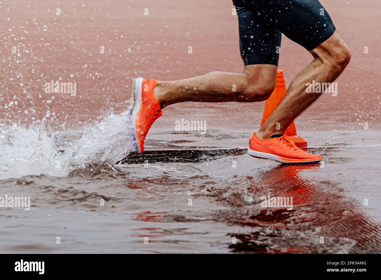 Beine männlicher Läufer, der ein Steeplechase-Rennen läuft, Meisterschafts-Wettkampf, Wasserspritzer Stockfoto