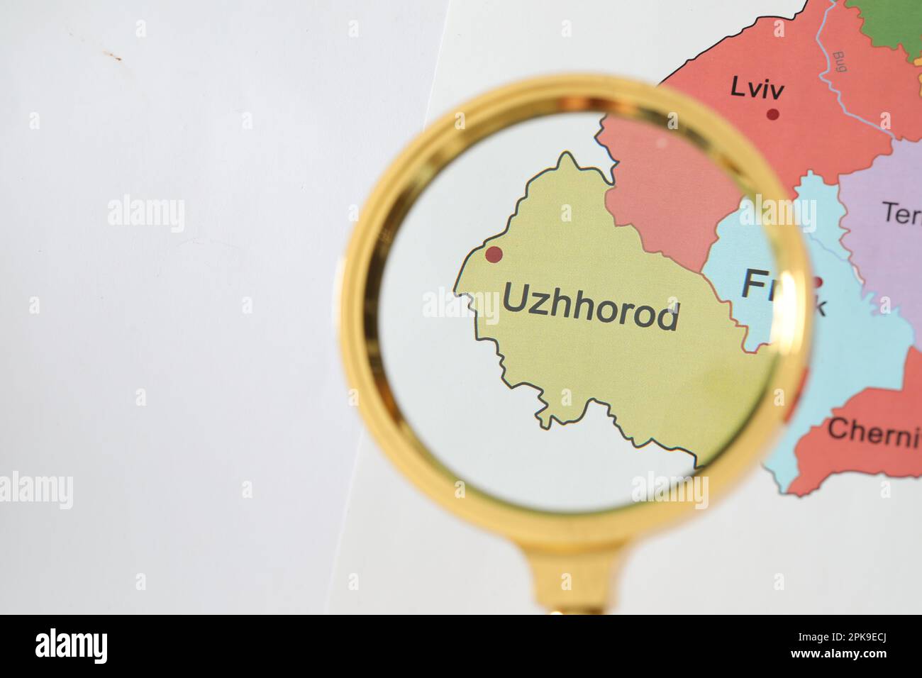 Goldenes Vergrößerungsglas über Uschhorod auf der Karte der Ukraine, Nahaufnahme Stockfoto