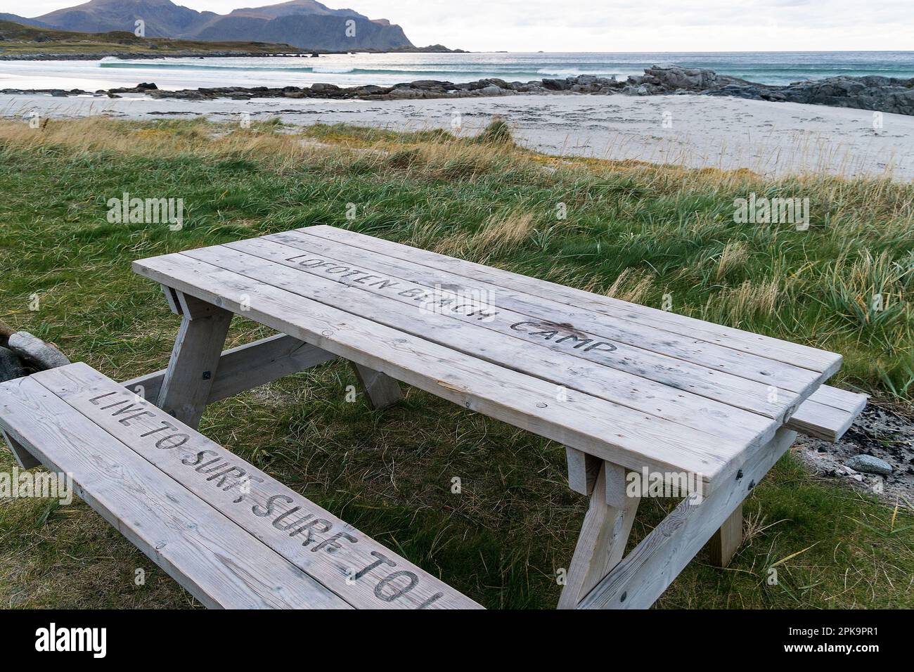 Norwegen, Lofoten, Flakstadoya, Küste nahe Flakstad, Strand, Lofoten Beach Camp, Tisch mit Bank, Ruhebereich Stockfoto