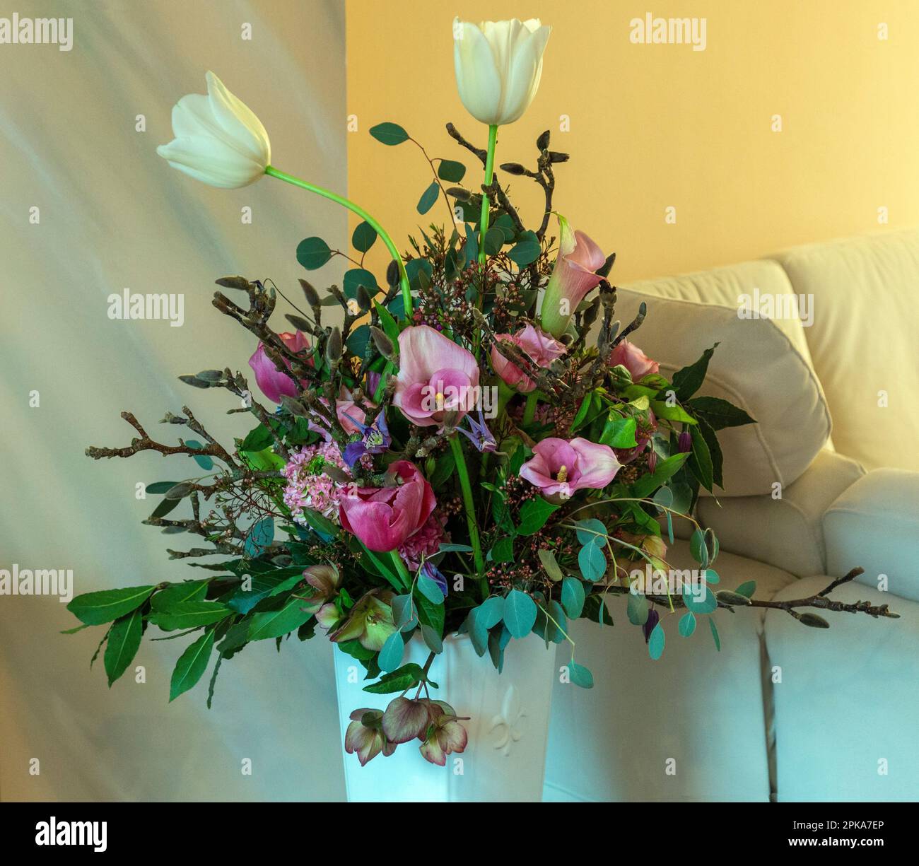 Blumen, Blumenstrauß, Geburtstag, Geburtstagsstrauß in einer Blumenvase, Tulpen, Rosen, Drachenwurz, Calla, Linsenrosen, Anemonen, Windrosen, Zweige der Magnolie Stockfoto