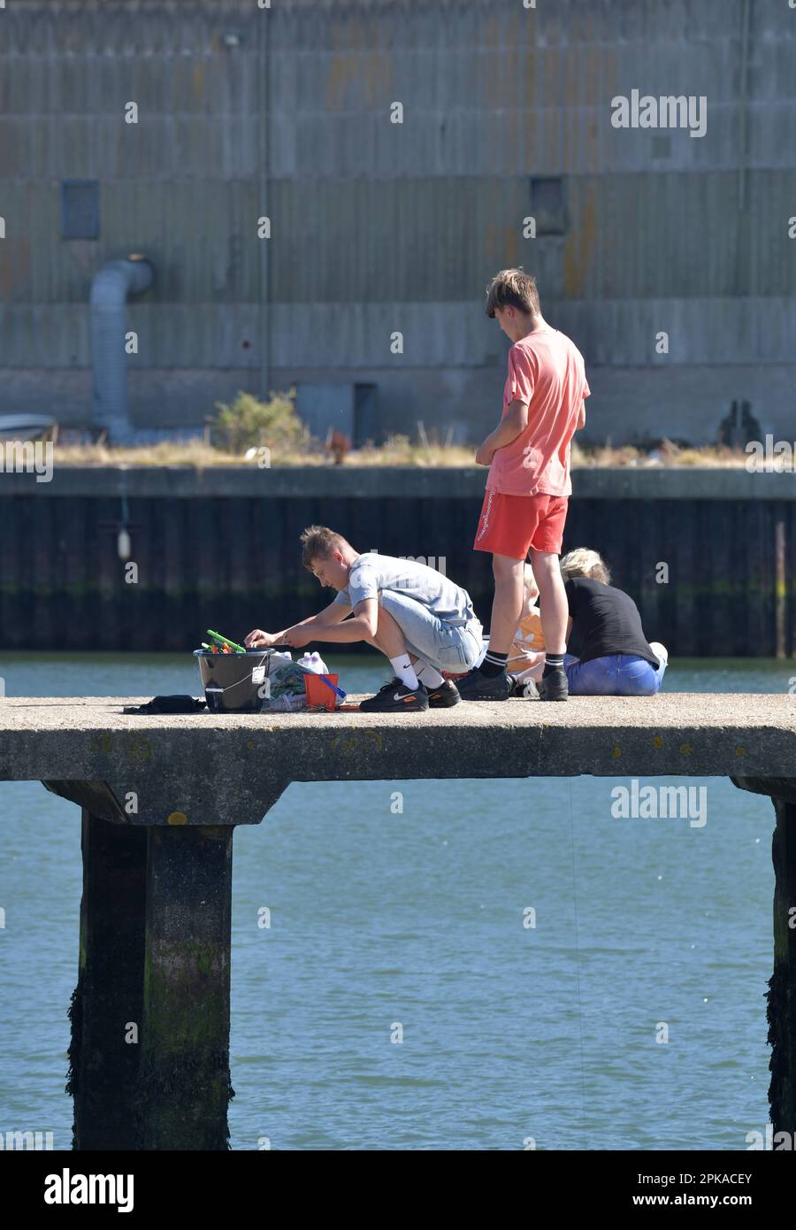 Eine Gruppe Teenager, die in Lake Lothing angeln, oulton Broad, lowestoft, suffolk, england Stockfoto