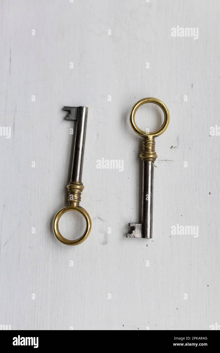 Zwei identische Schlüssel auf einem weißen Holztisch Stockfoto