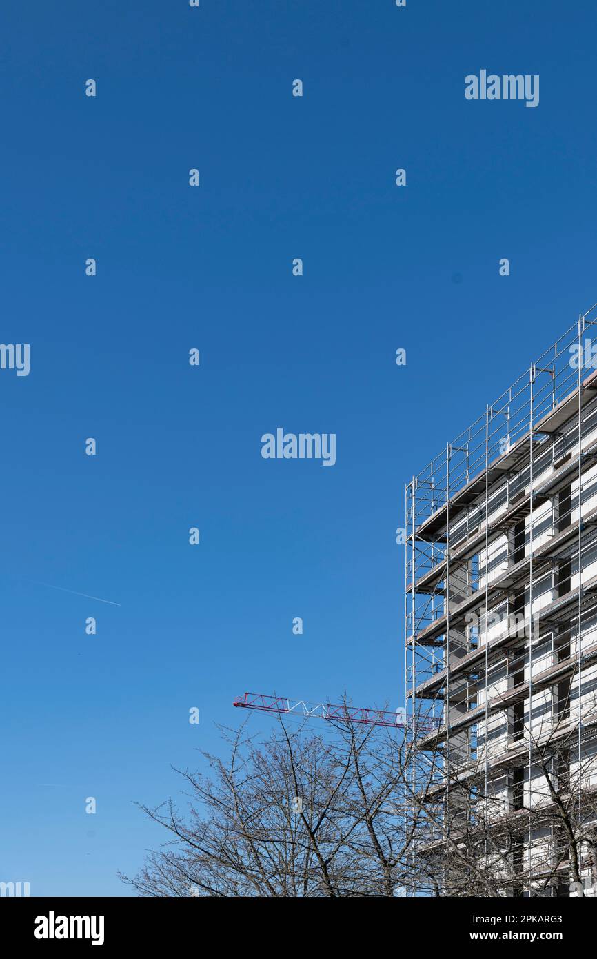 Mehrstöckiges Gerüstgebäude in Schale vor hellblauem Himmel Stockfoto