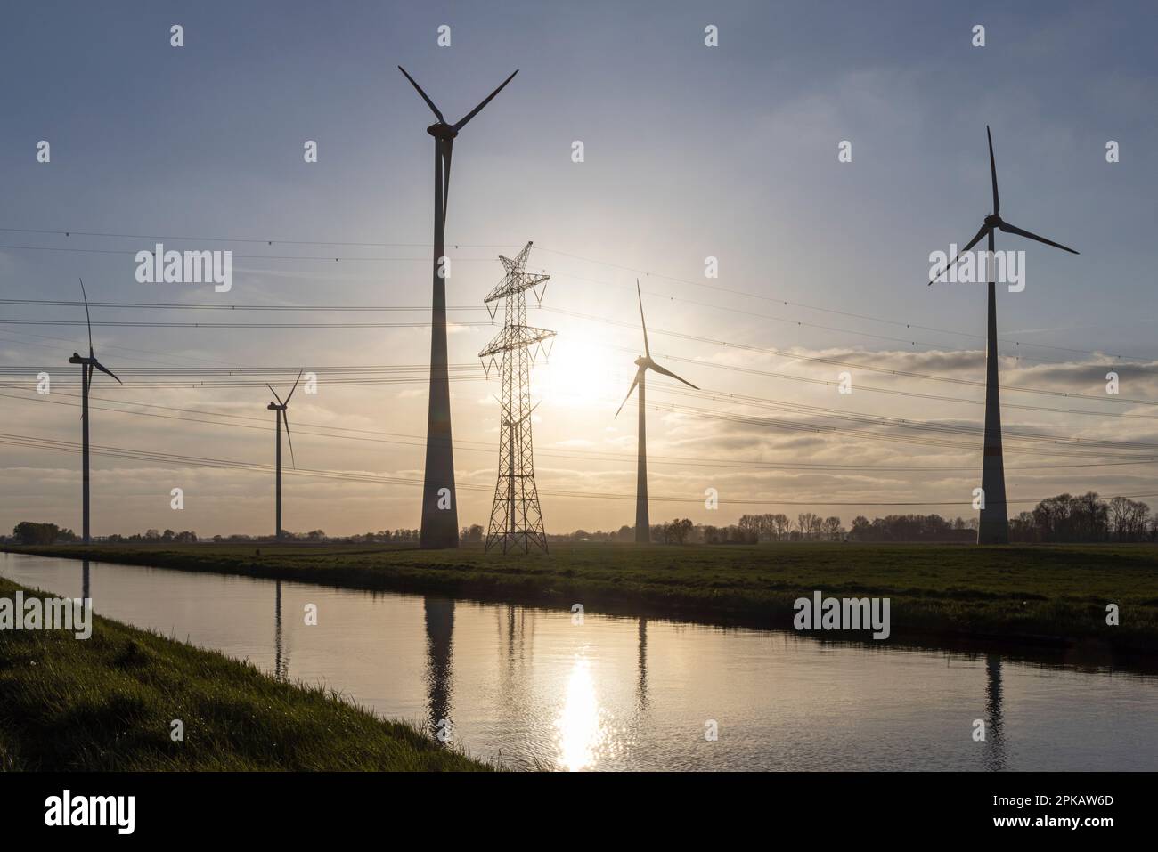 Abendlicht kurz vor Sonnenuntergang, Hochspannungsleitung, Windturbine am Ems-Jade-Kanal der Friesen-Elektra II GmbH & Co KG, in Sande, Gemeinde Friesland, Niedersachsen, Deutschland. Stockfoto