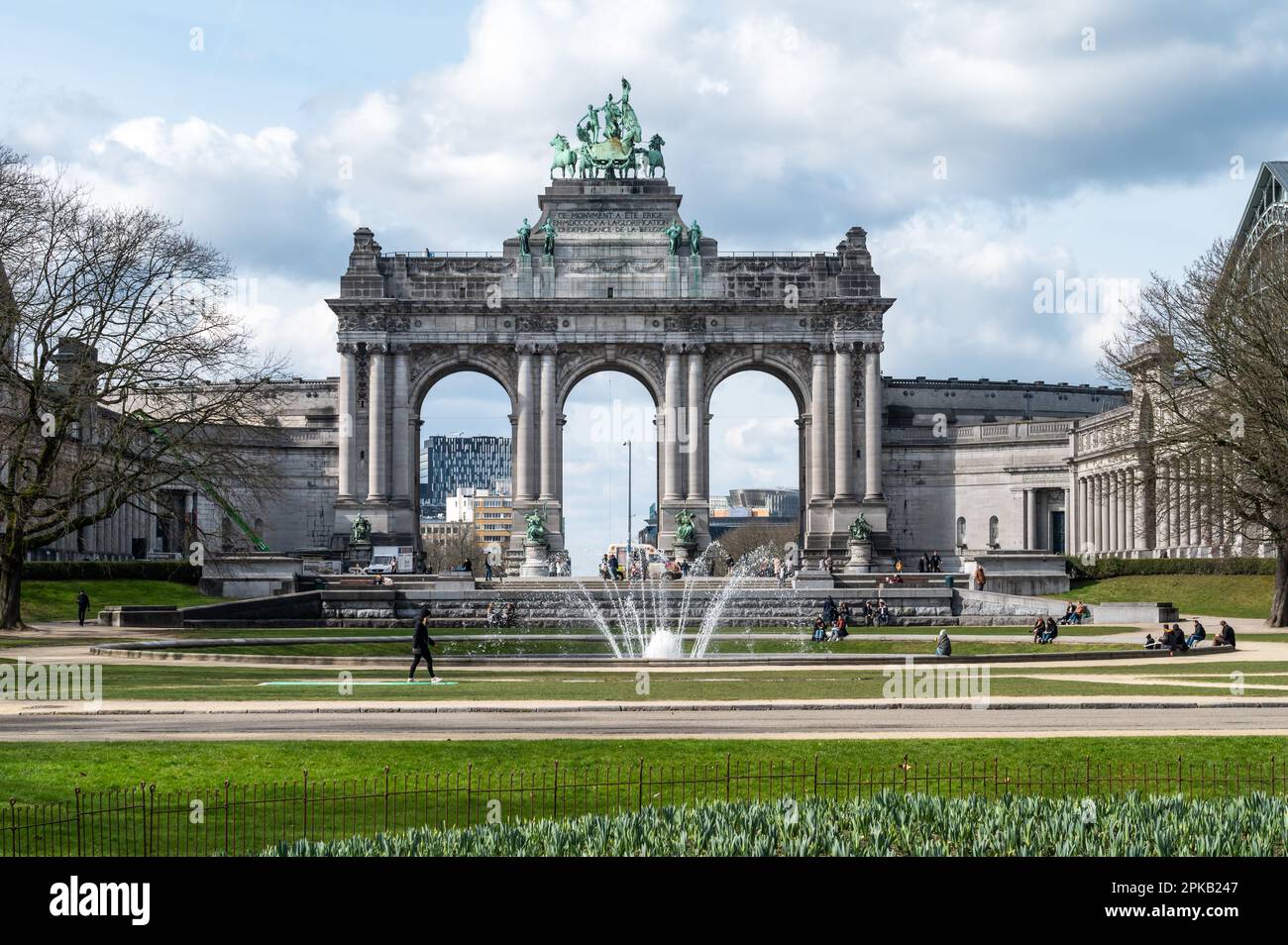 Europäisches Viertel Brüssel, Belgien - 15. März 2023 - der Triumphbogen im Park Cinquentenaire mit grünem Rasen und einem Brunnen Stockfoto