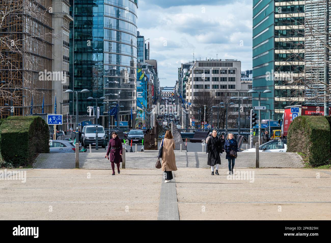 Europäisches Viertel Brüssel, Belgien - 15. März 2023 - Menschen, die auf der Schuman-Promenade mit der Rue de la Loi im Hintergrund laufen Stockfoto
