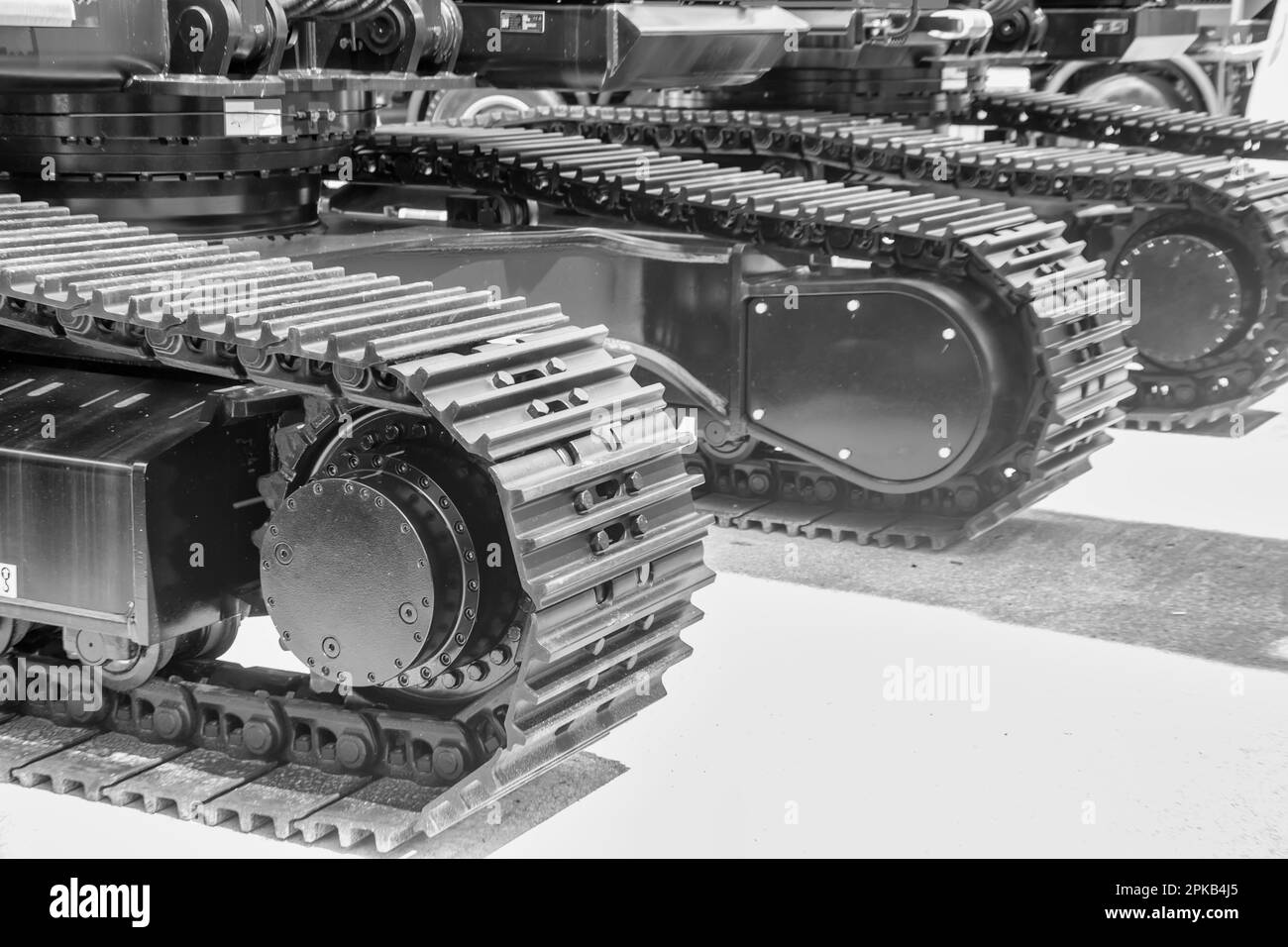 Caterpillar-Ketten in Schwarz-Weiß, Fahrwerk einer schweren Baumaschine. Stockfoto
