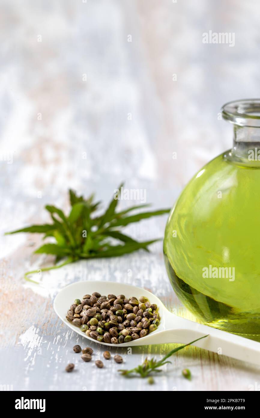 Flasche mit organischem Hanföl, Blättern und Samen. Stockfoto