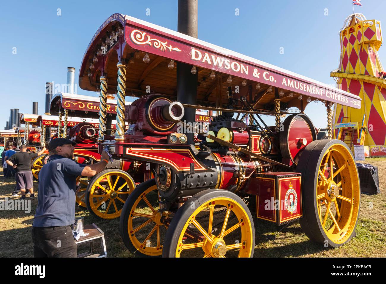England, Dorset, die jährliche Great Dorset Steam Fair in Tarrant Hinton in der Nähe des Blandford Forum, man Cleaning and Polishing Colourful Steam Engine Stockfoto