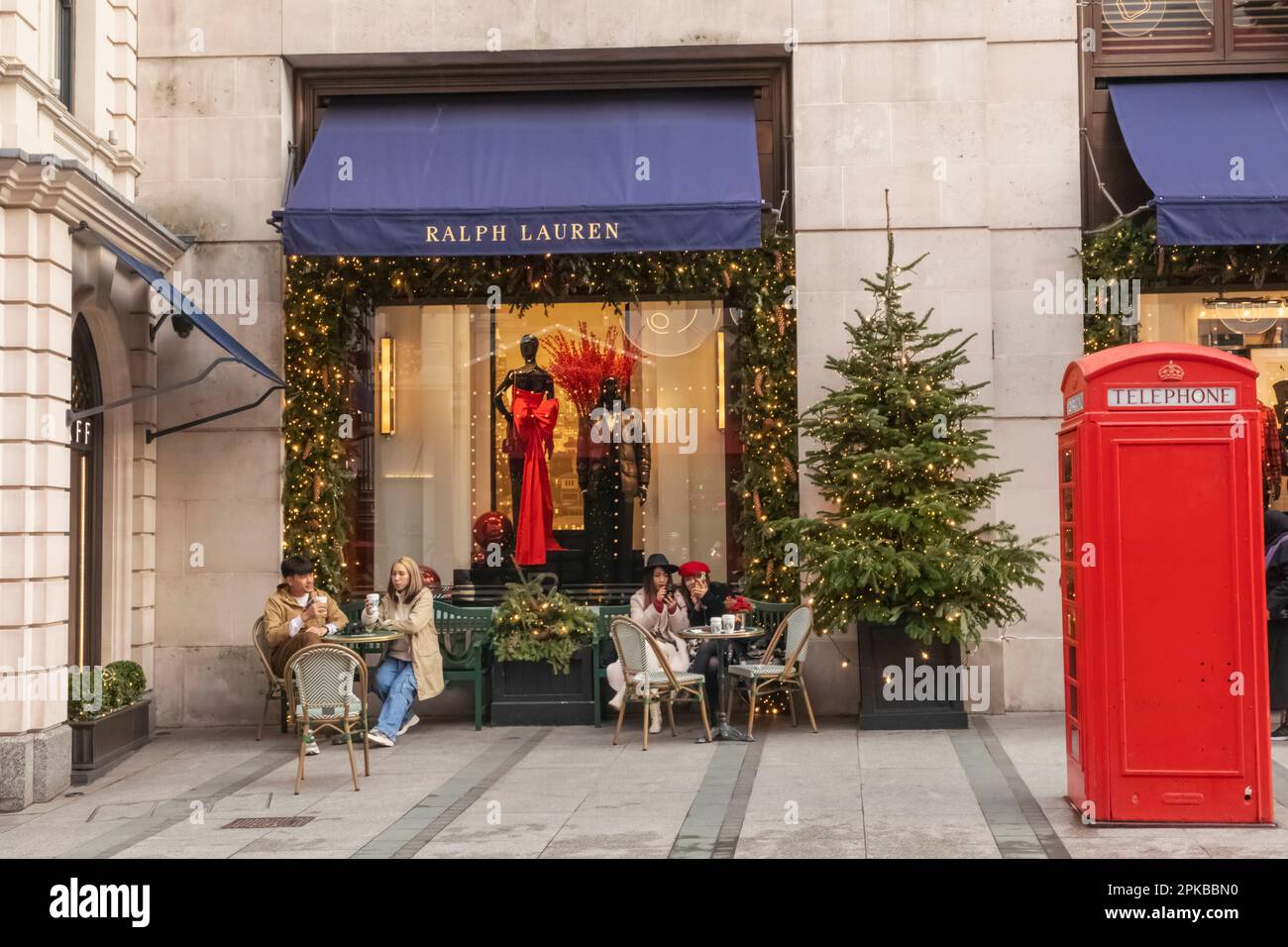 England, London, Piccadilly, New Bond Street, Außenansicht des Ralph Lauren Store mit Weihnachtsdekorationen und traditioneller roter Telefonzelle Stockfoto