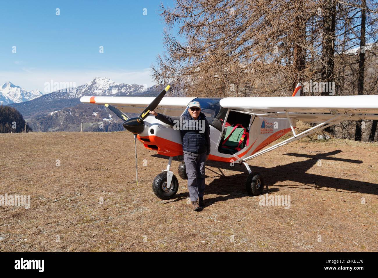 Der Pilot steht neben einem leichten Flugzeug, nachdem er auf einem Feldflugplatz in Chamois im Aostatal Italien gelandet ist Stockfoto