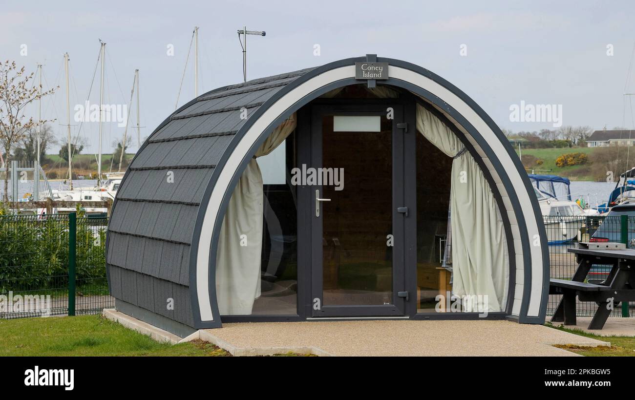 Nordirland Glamping pod neben Booten im Süßwasserhafen. Coney Island Glamping Pod Teil der Island Pods Gruppe, die man in Kinnego Lough Neagh mieten kann. Stockfoto