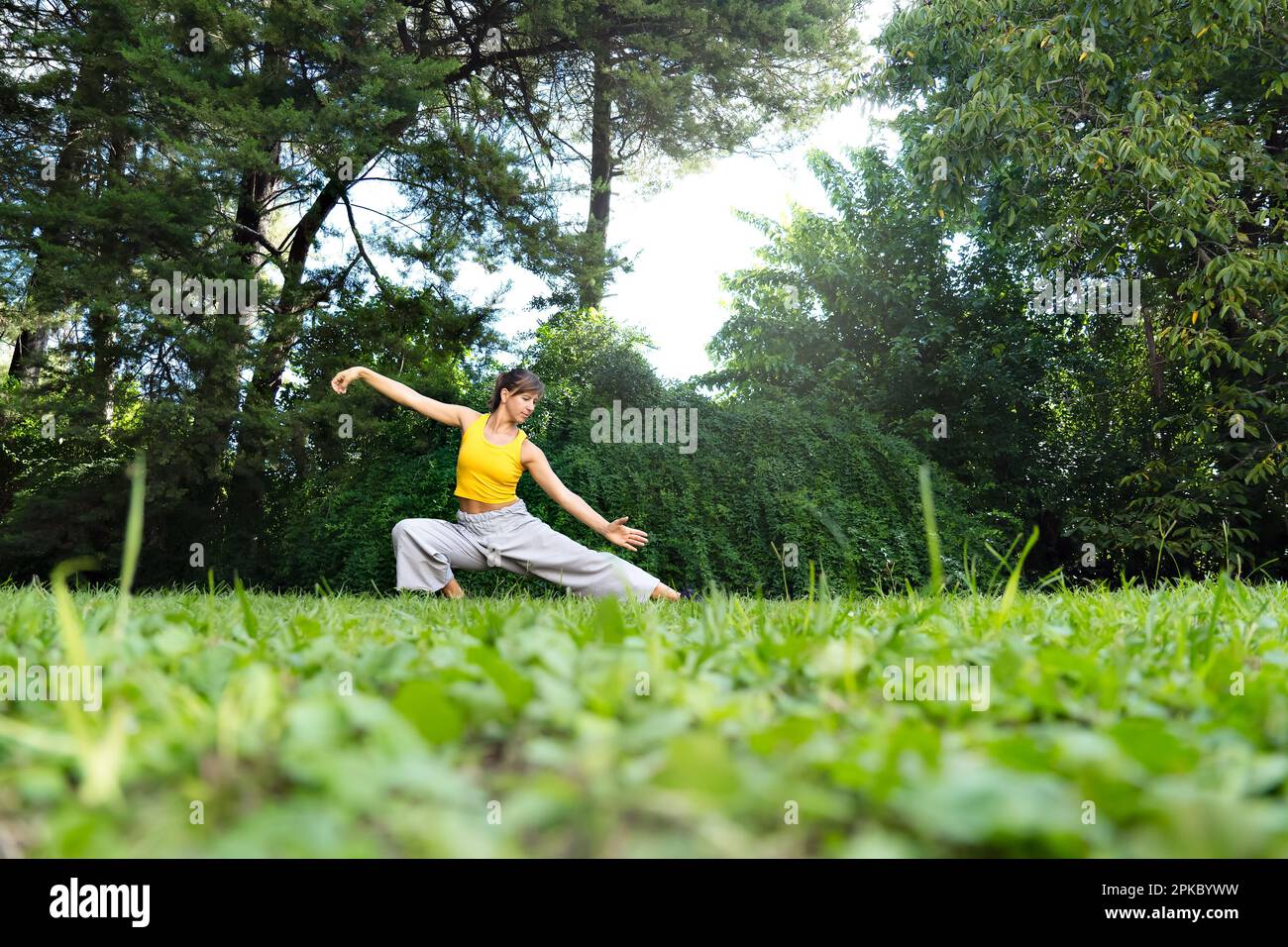 Eine Frau, die draußen Tai Chi Chuan praktiziert. Das Üben von Tai Chi kann dazu beitragen, die Flexibilität, Kraft und das Gleichgewicht des Körpers zu verbessern und Stress zu reduzieren Stockfoto