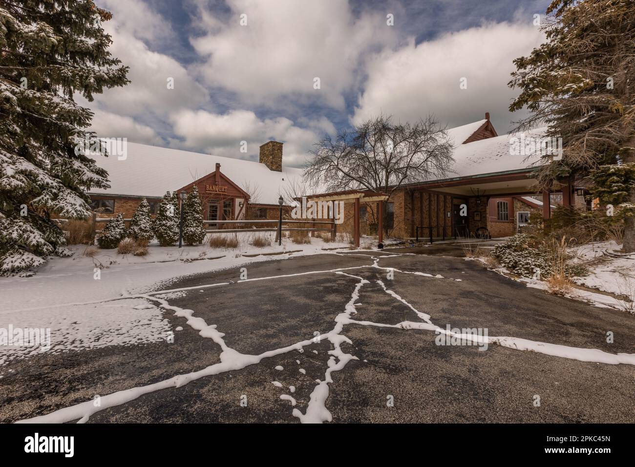 Verlassene alte Bar (Backsteingebäude) in Michigan mit Schnee bedeckt. Ein großer Hof davor. Winterzeit. Stockfoto