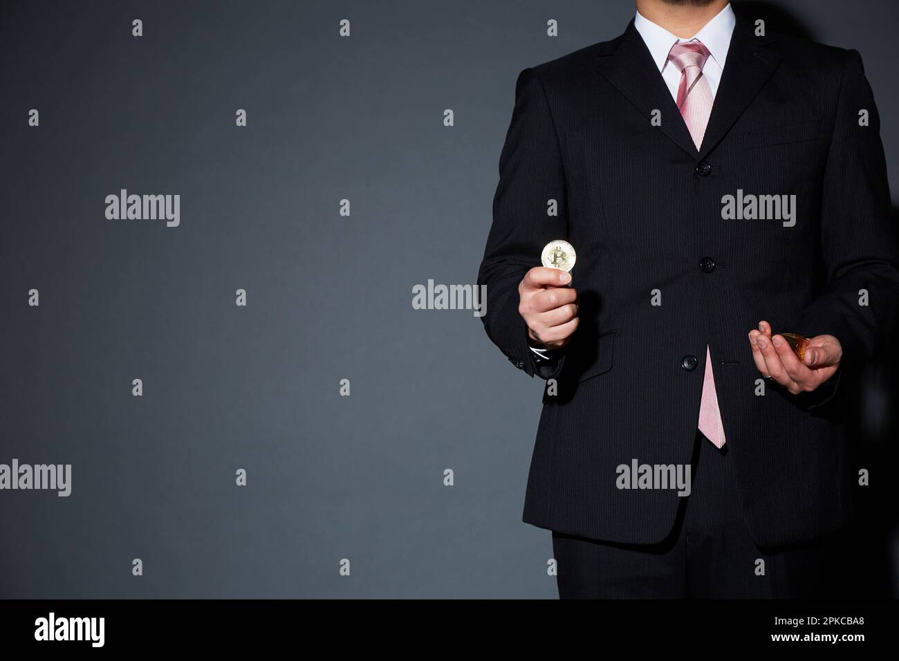Mann im Anzug mit Bitcoins Stockfoto