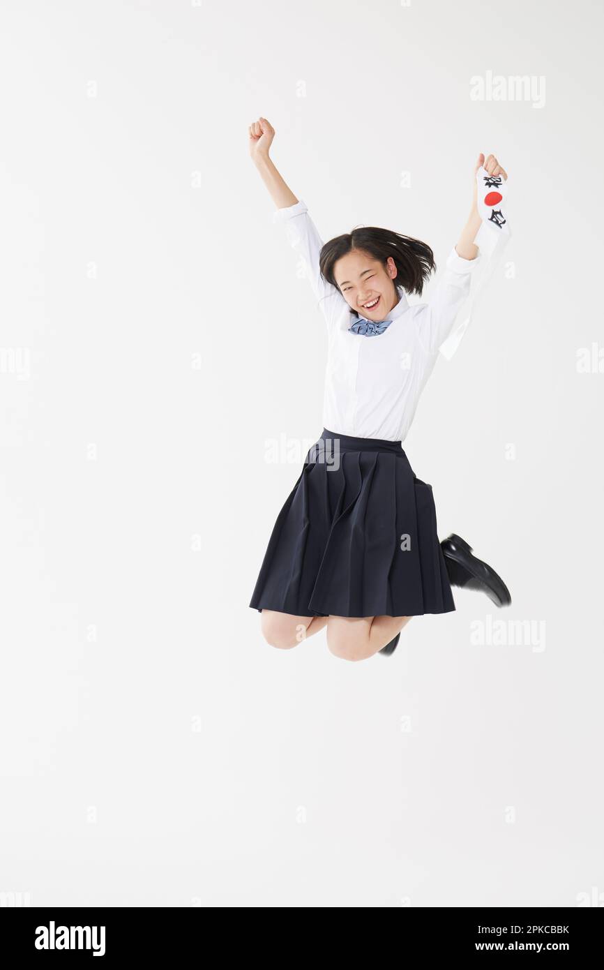 Ein Highschool-Mädchen hüpfte auf und ab, während es ihr „Hachimaki“ (Taschentuch) hielt Stockfoto