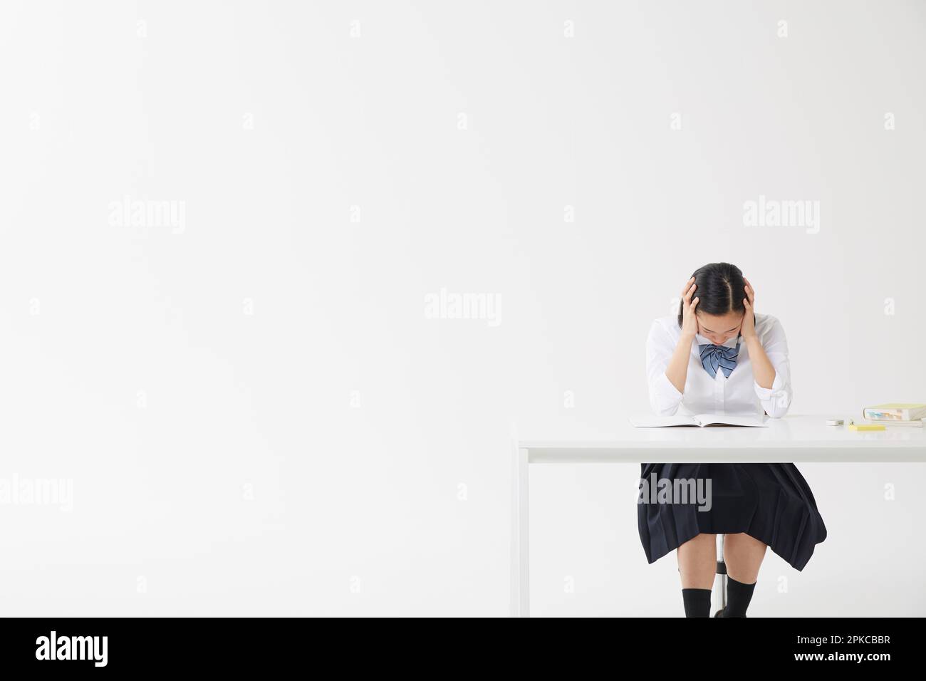 Highschool-Mädchen, die lernt und ihren Kopf hält Stockfoto