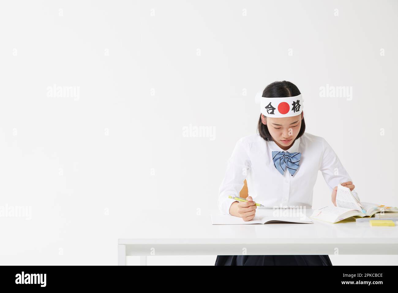 Ein Highschool-Mädchen, das während des Studiums ein "Hachimaki" trägt Stockfoto