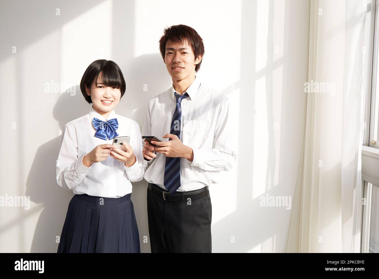 Ein Highschool-Junge und ein Highschool-Mädchen mit einem Smartphone Stockfoto