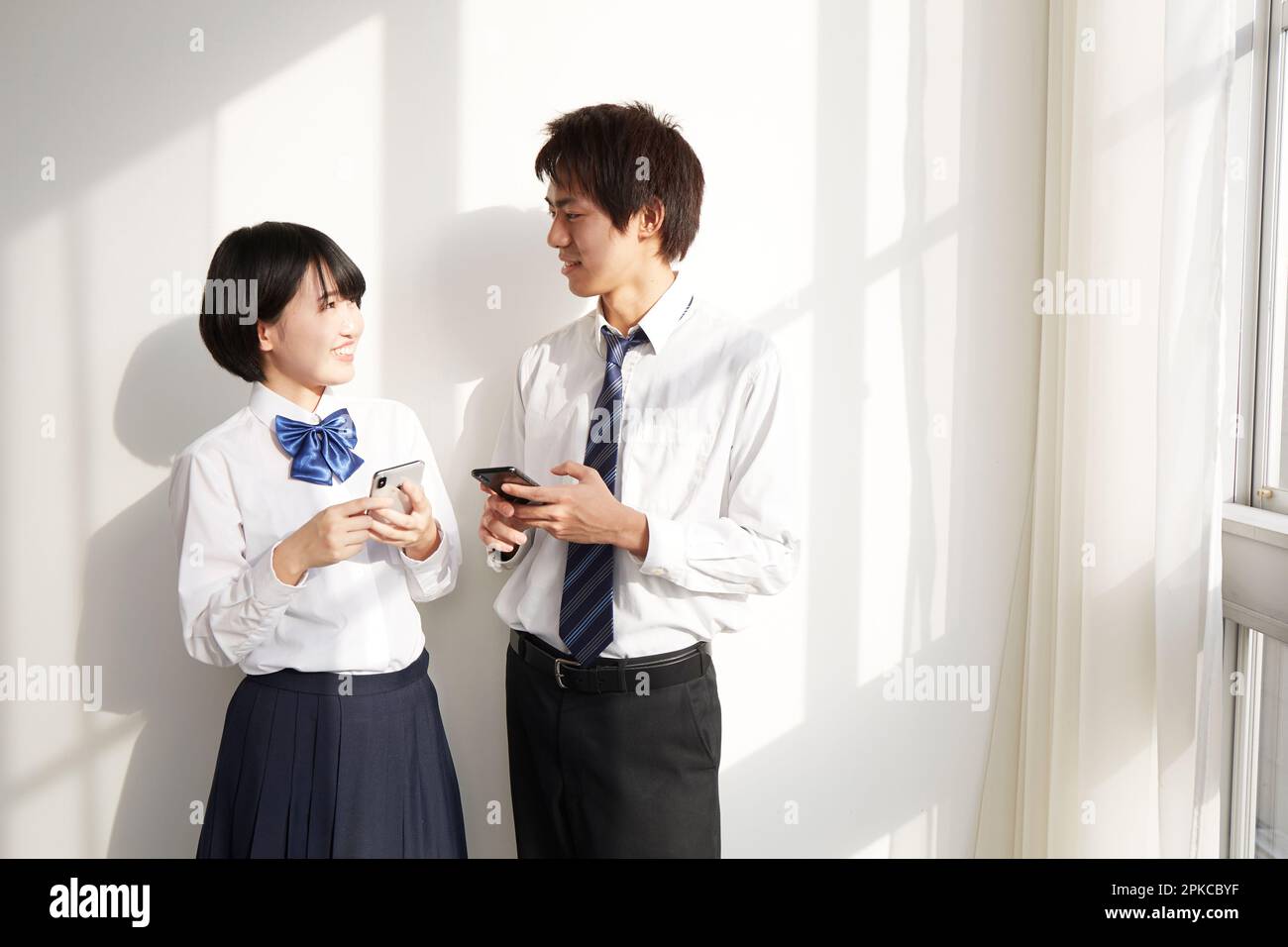 Ein Highschool-Junge und ein Highschool-Mädchen mit einem Smartphone Stockfoto