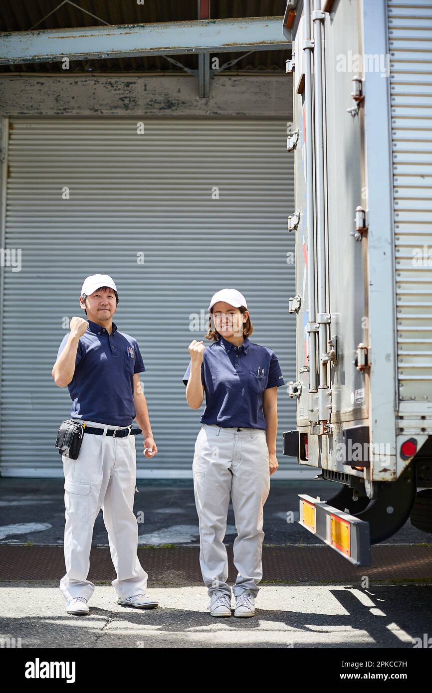Mann und Frau, die sich neben einem großen Truck posieren Stockfoto