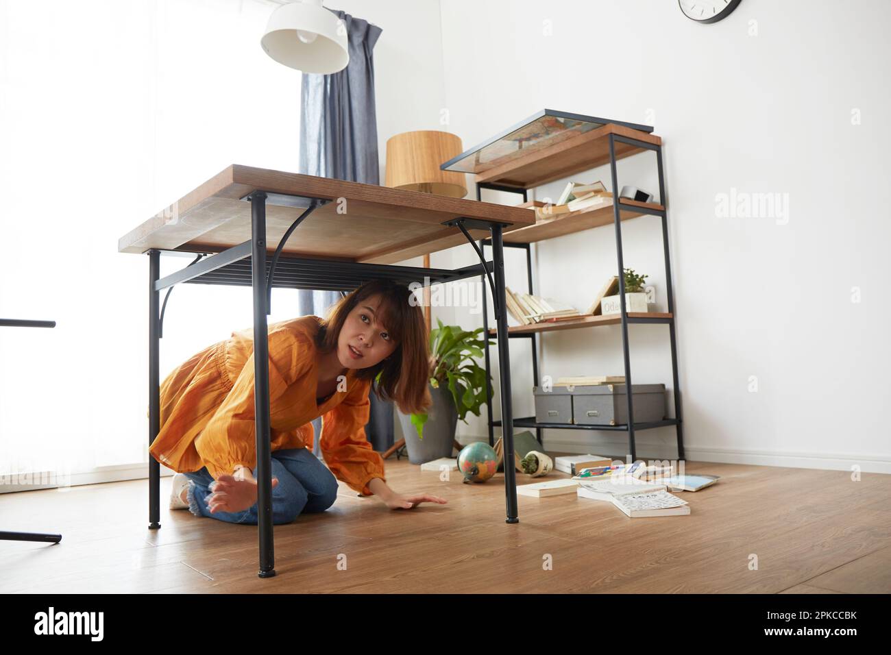 Eine Frau, die zu Hause Angst vor einem Erdbeben hat Stockfoto