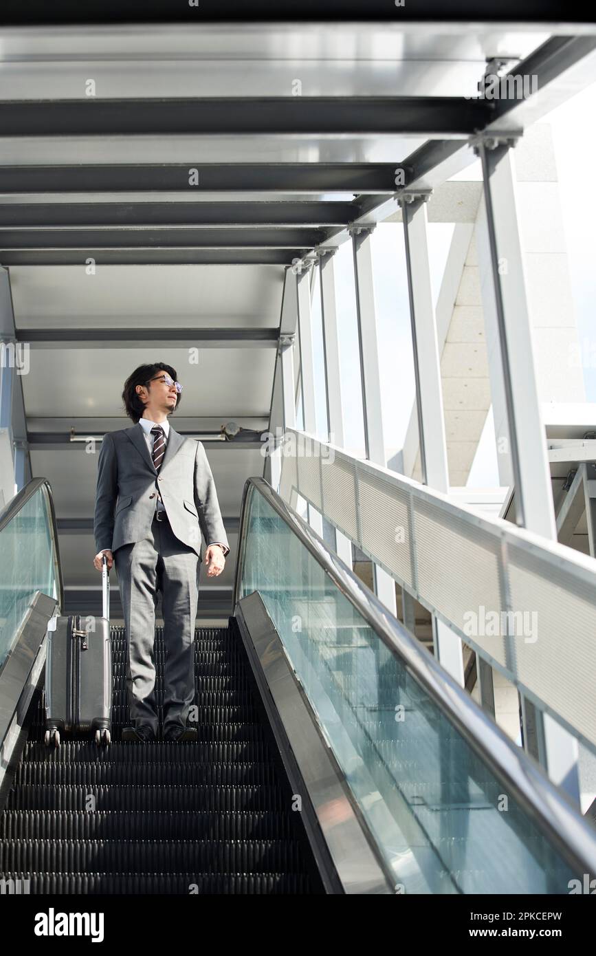 Büroangestellter auf einer Rolltreppe Stockfoto