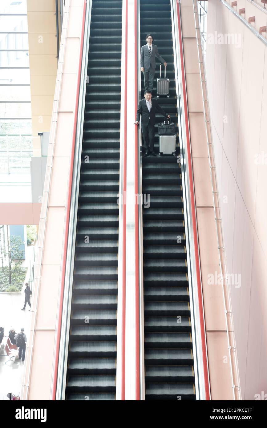 Büroangestellter auf der Rolltreppe Stockfoto