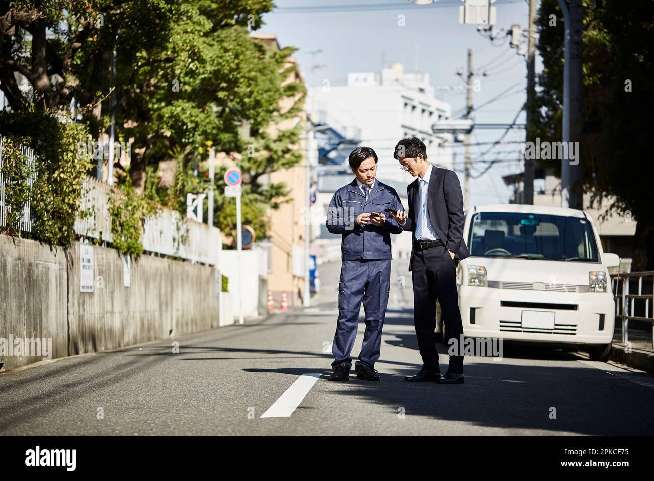 Zwei Männer stehen vor einem Auto und reden Stockfoto