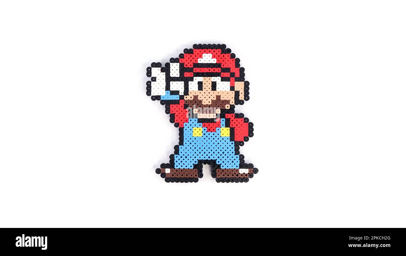 Beliebtes 8-Bit-Spielzeug aus Kunststoff Super Mario auf weißem Hintergrund. Super Mario Handgemachtes Spielzeug von Perler Perlen auf Weiß. Gatineau, QC Kanada - 30.03.2023 Stockfoto