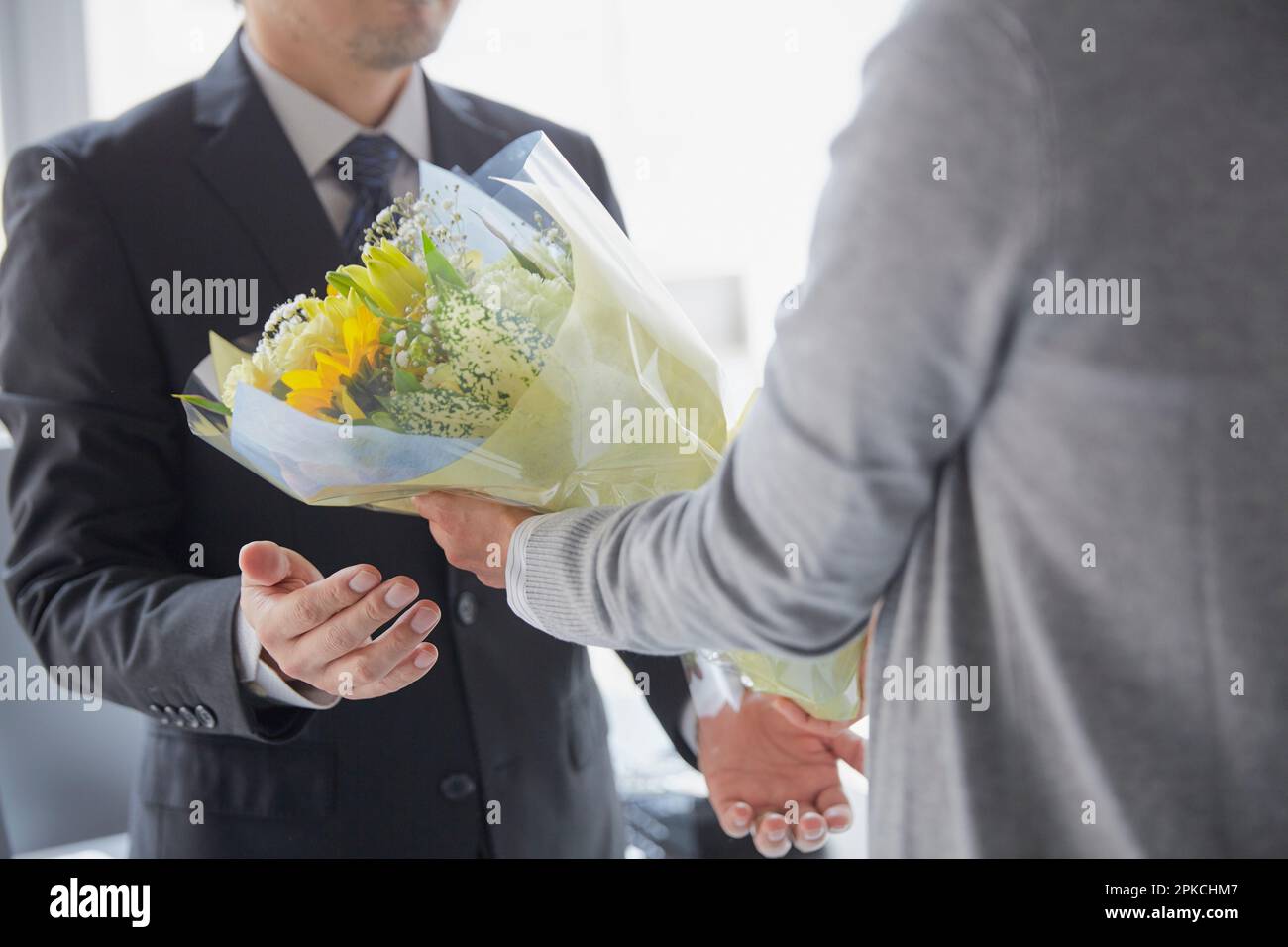 Eine Mitarbeiterin, die ihrem Chef Blumen schickt, um ihm zu seinem Ruhestand zu gratulieren Stockfoto