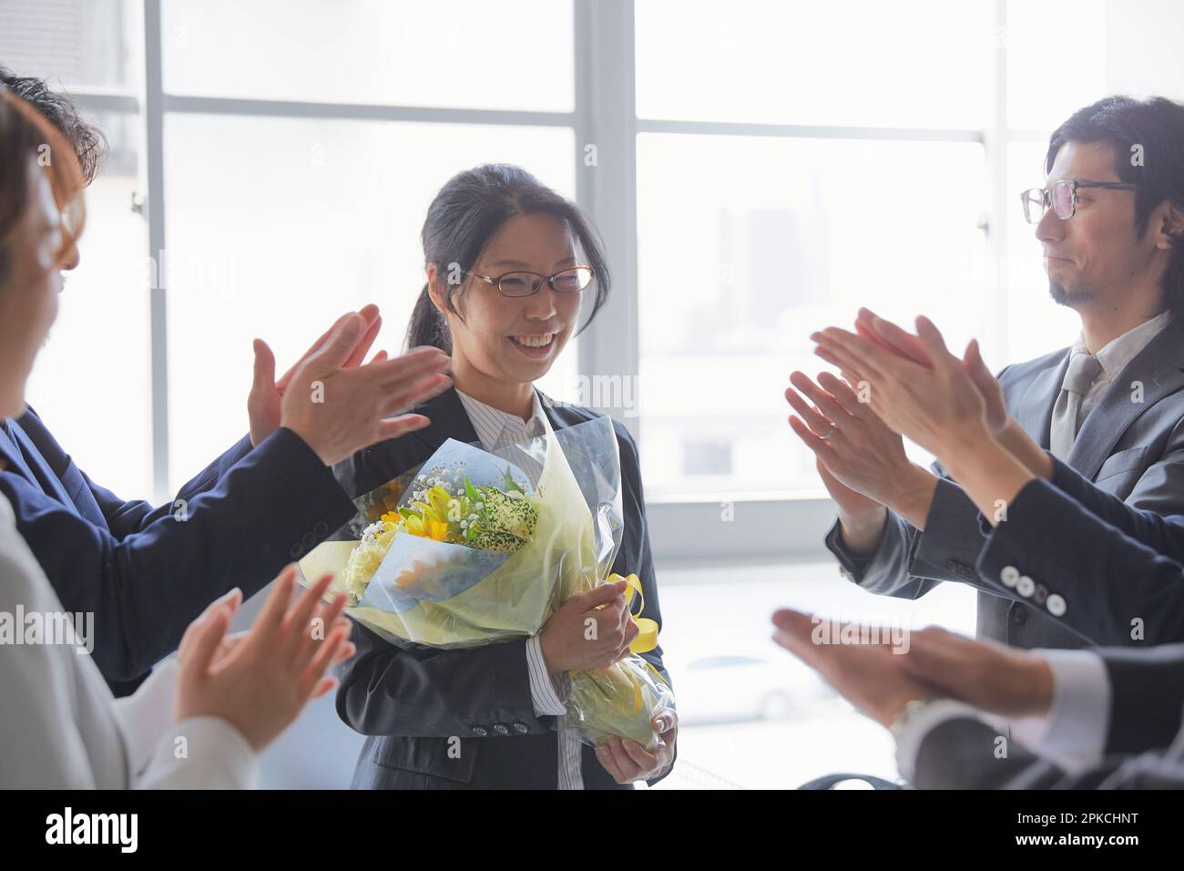 Eine Mitarbeiterin, die ihrem Chef zu seinem Ruhestand gratuliert Stockfoto