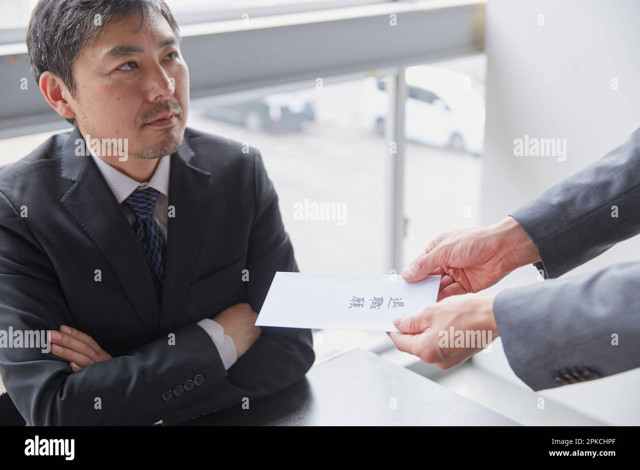 Ein Mitarbeiter, der seine Kündigung einreicht, und sein Vorgesetzter, der nicht zufrieden ist Stockfoto