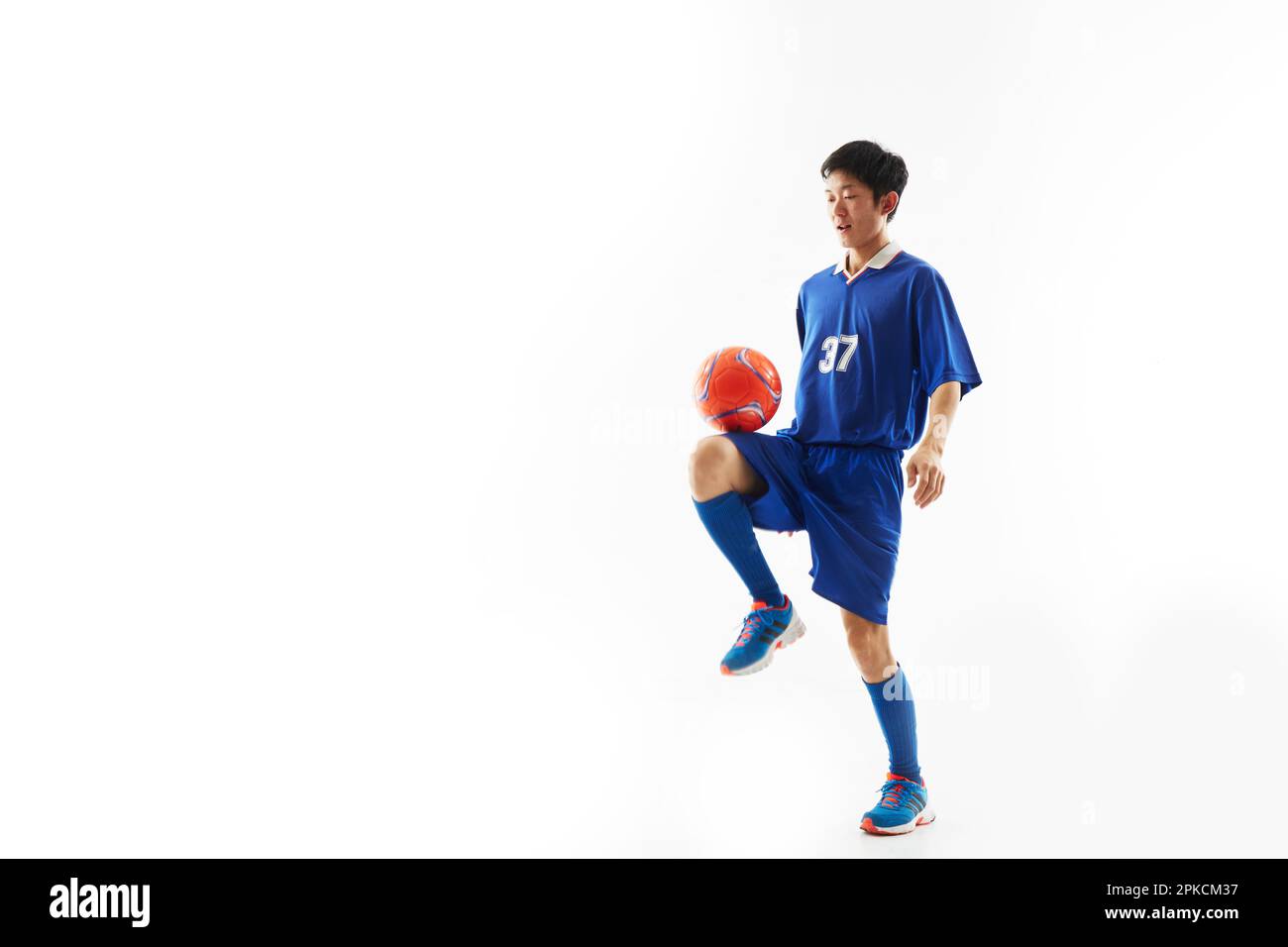 Ein Fußballspieler, der einen Ball hebt Stockfoto