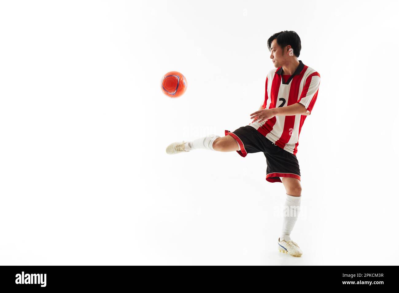 Ein Fußballspieler, der einen Ball hebt Stockfoto