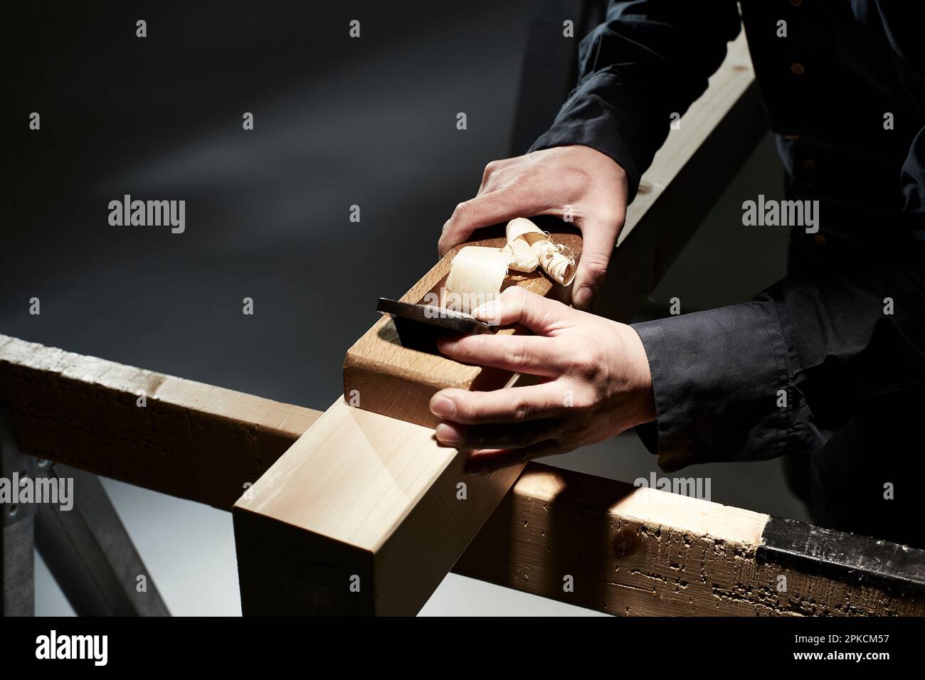 Männerhände schärfen Holz Stockfoto