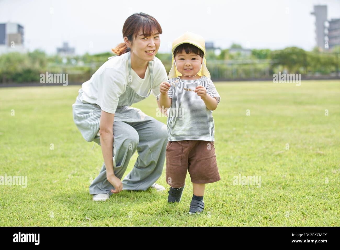 Kinderbetreuerin mit Kind, die auf dem Rasen spielt Stockfoto