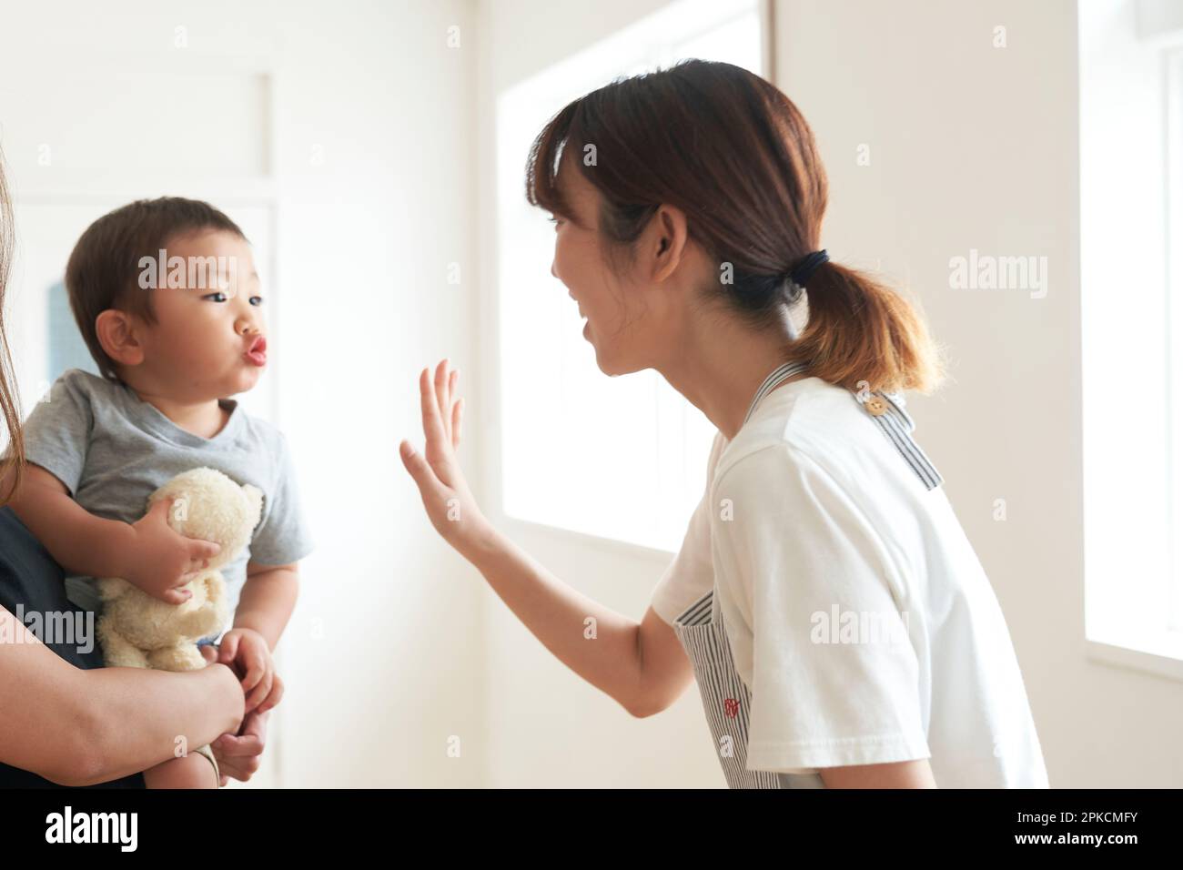 Kinderbetreuerin winkt Kindern zu, die nach Hause kommen Stockfoto