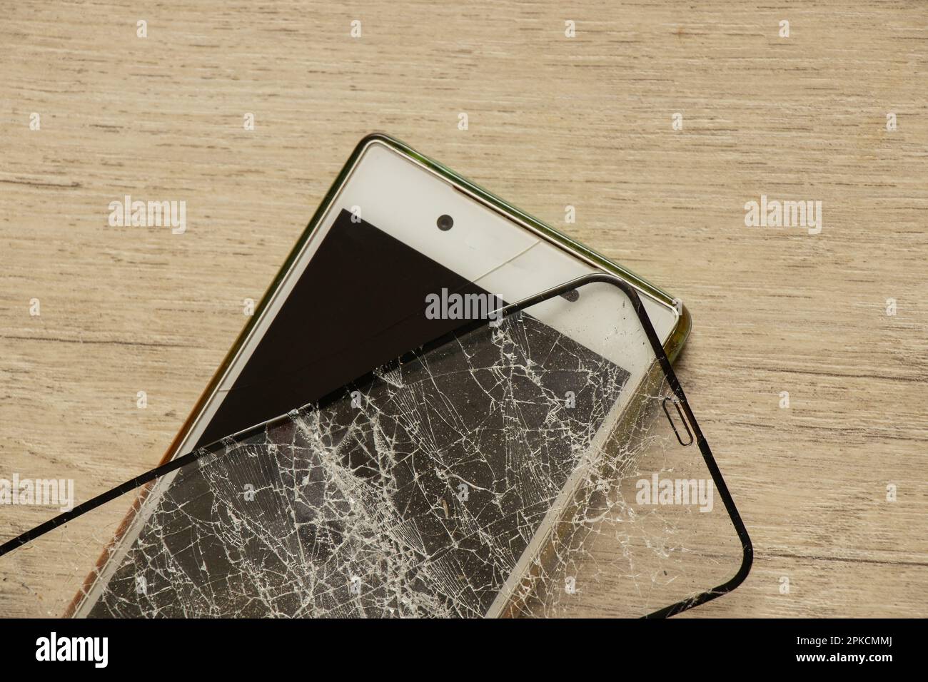 Mobiltelefon und zerbrochenes gehärtetes Glas auf isoliertem Hintergrund, Glasaustausch Stockfoto