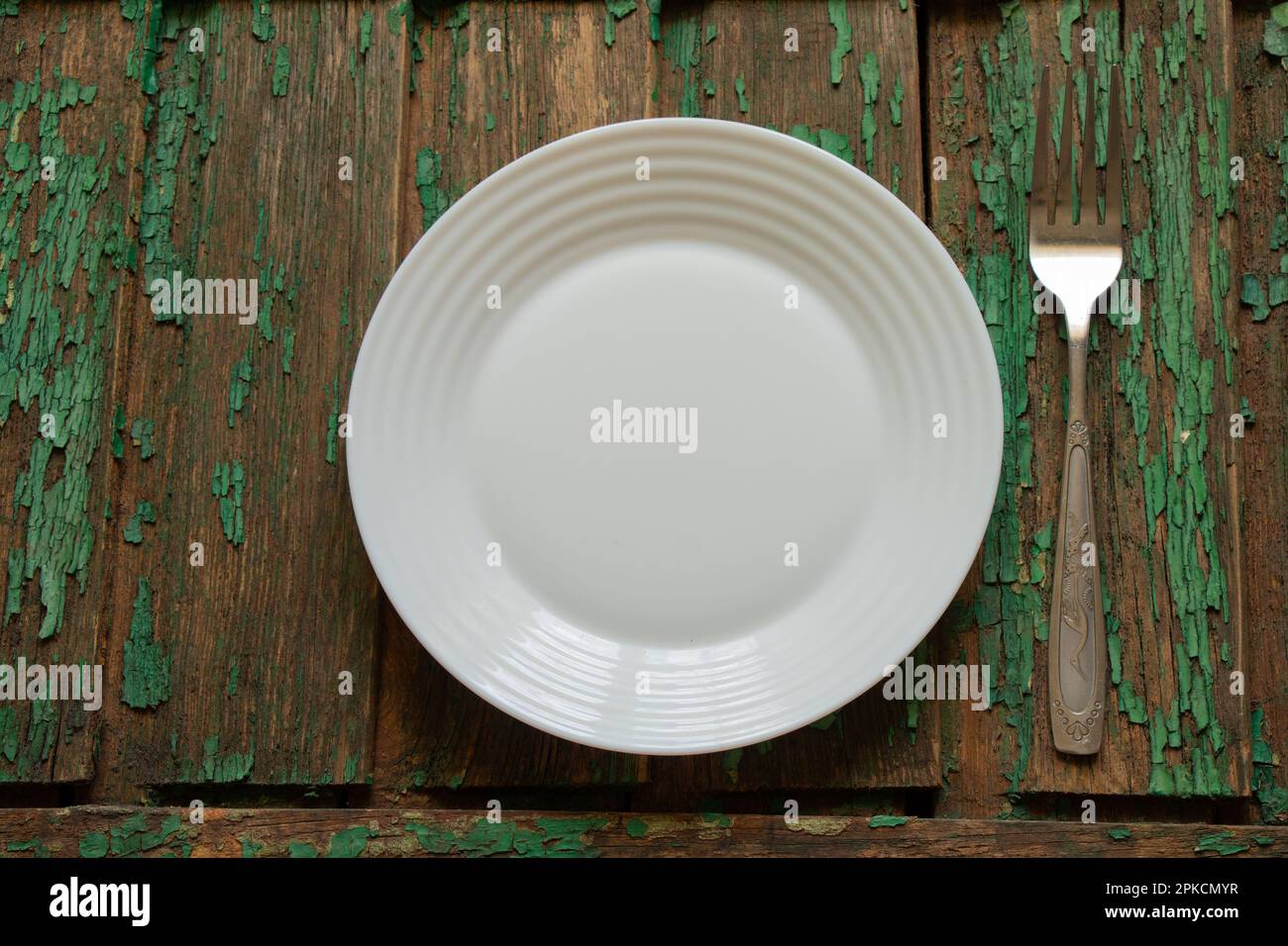 Weiße saubere leere Platte und Gabel auf Holztisch Stockfoto