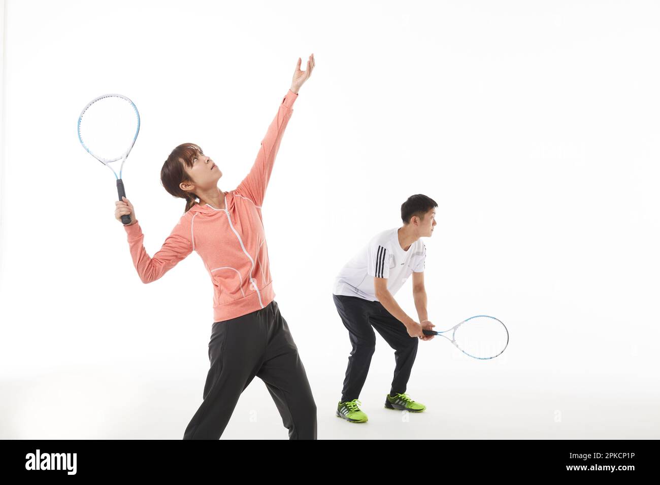 Männer und Frauen, die in Tennis-Doppeln dienen Stockfoto