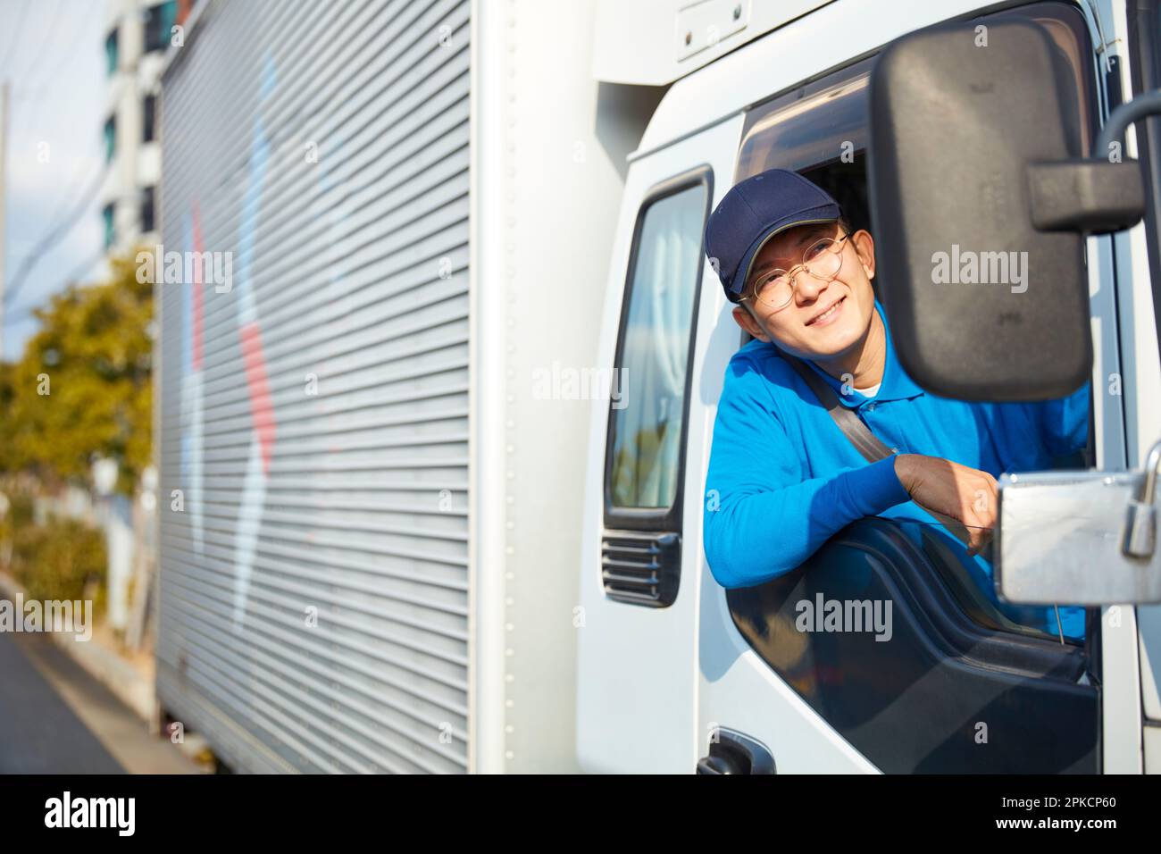 Ein Mann in Arbeitskleidung, der einen Lastwagen fährt Stockfoto