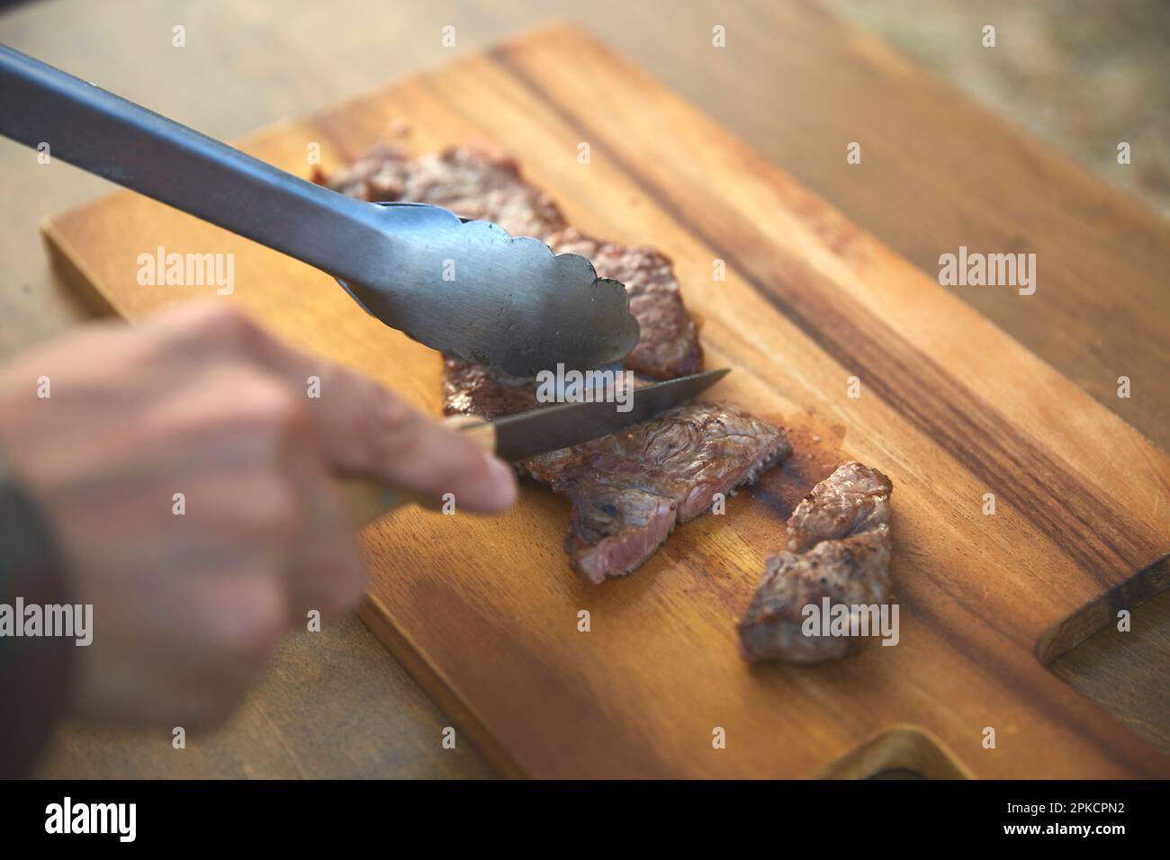 Männersteak von Hand schneiden Stockfoto