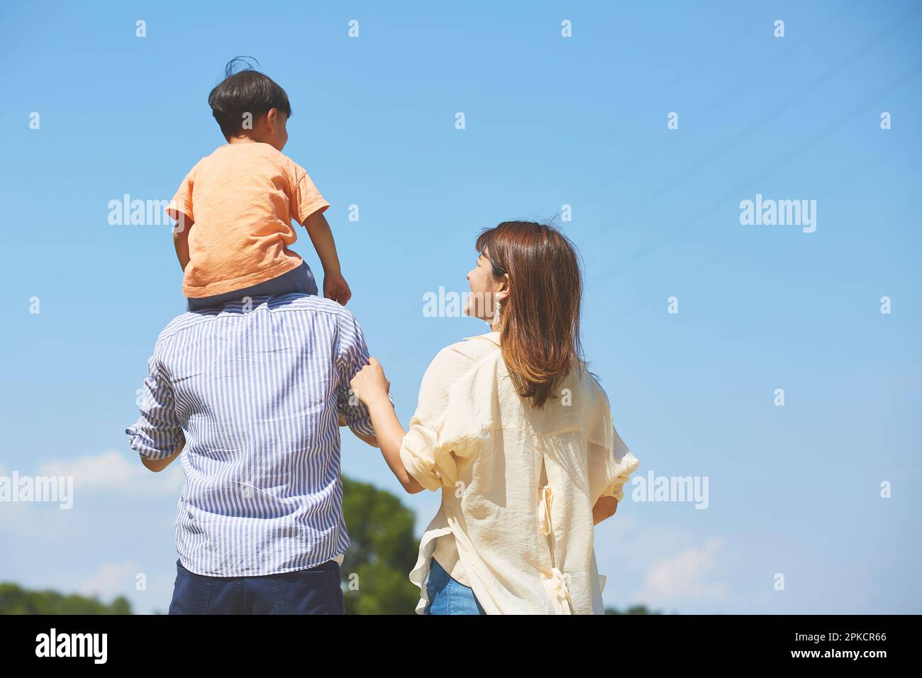 Vater trug sein Kind auf der Schulter und Mutter lehnte sich dicht hinter sich Stockfoto
